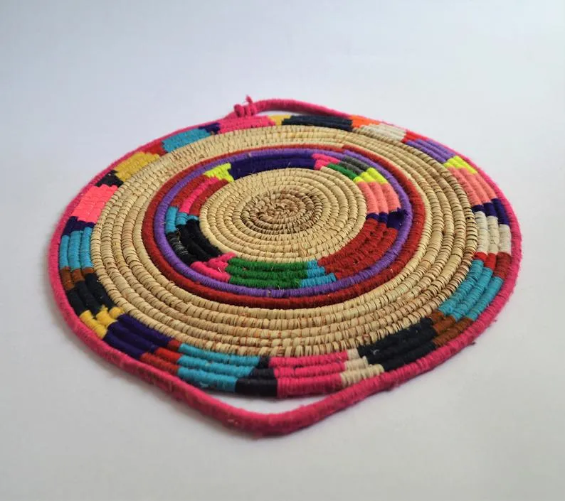 Tribal woven wall basket with wool decoration